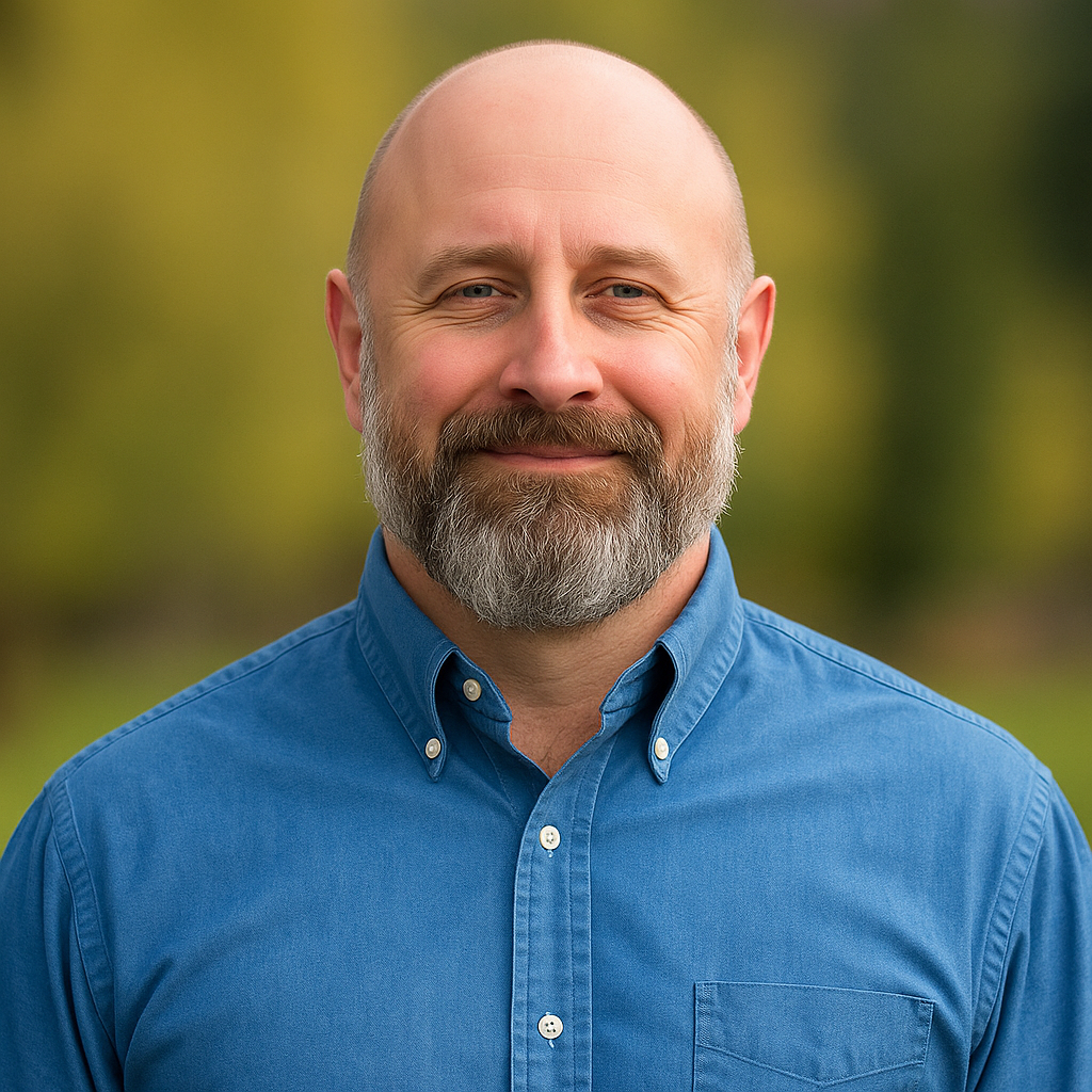 David Franke Jr., owner of Regent Construction, smiling in blue shirt with outdoor background