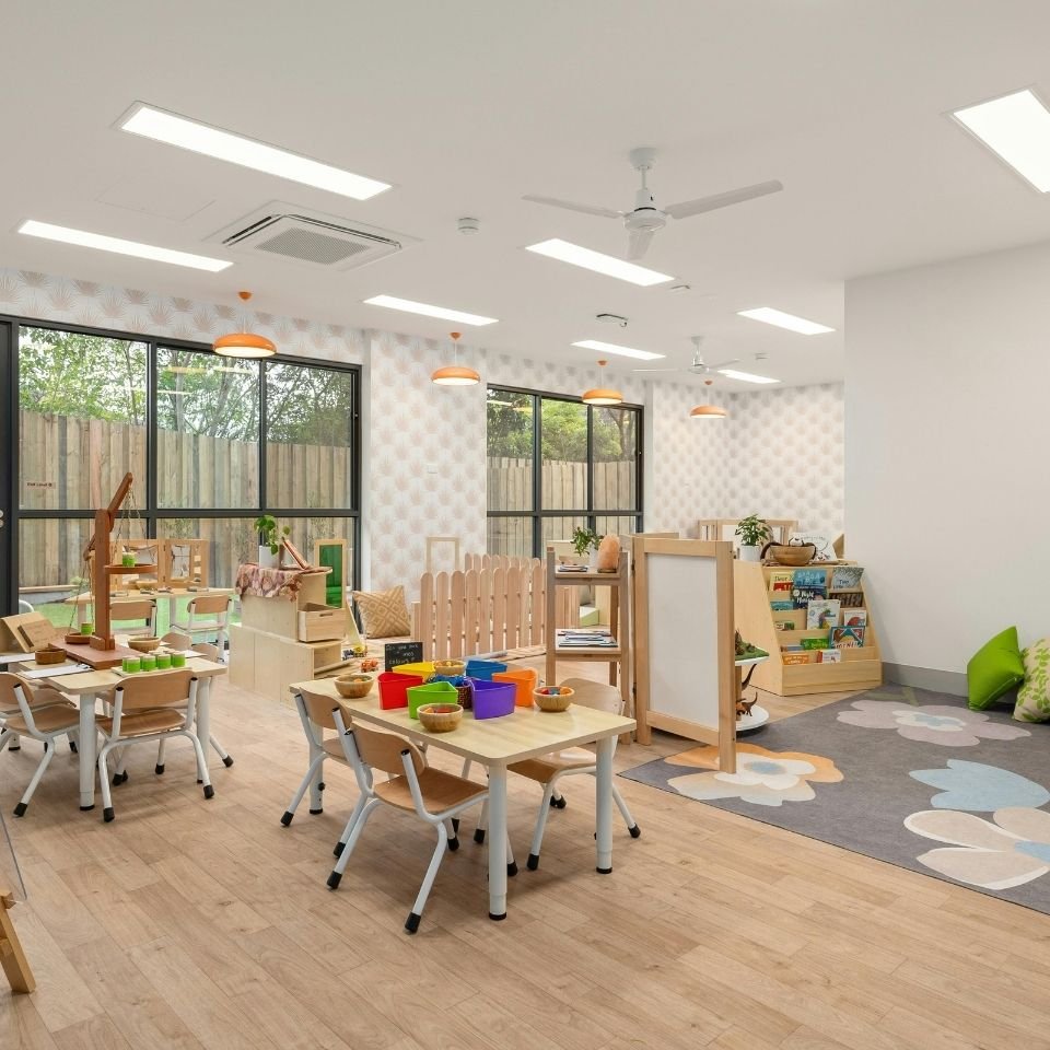 Preschool classroom with colorful furniture, natural lighting, and educational play areas
