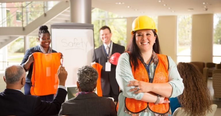 Construction team in safety vests attending a jobsite briefing with female project leader in focus