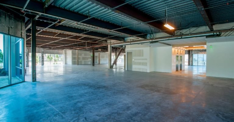 Open commercial interior with exposed ceilings and polished concrete floors