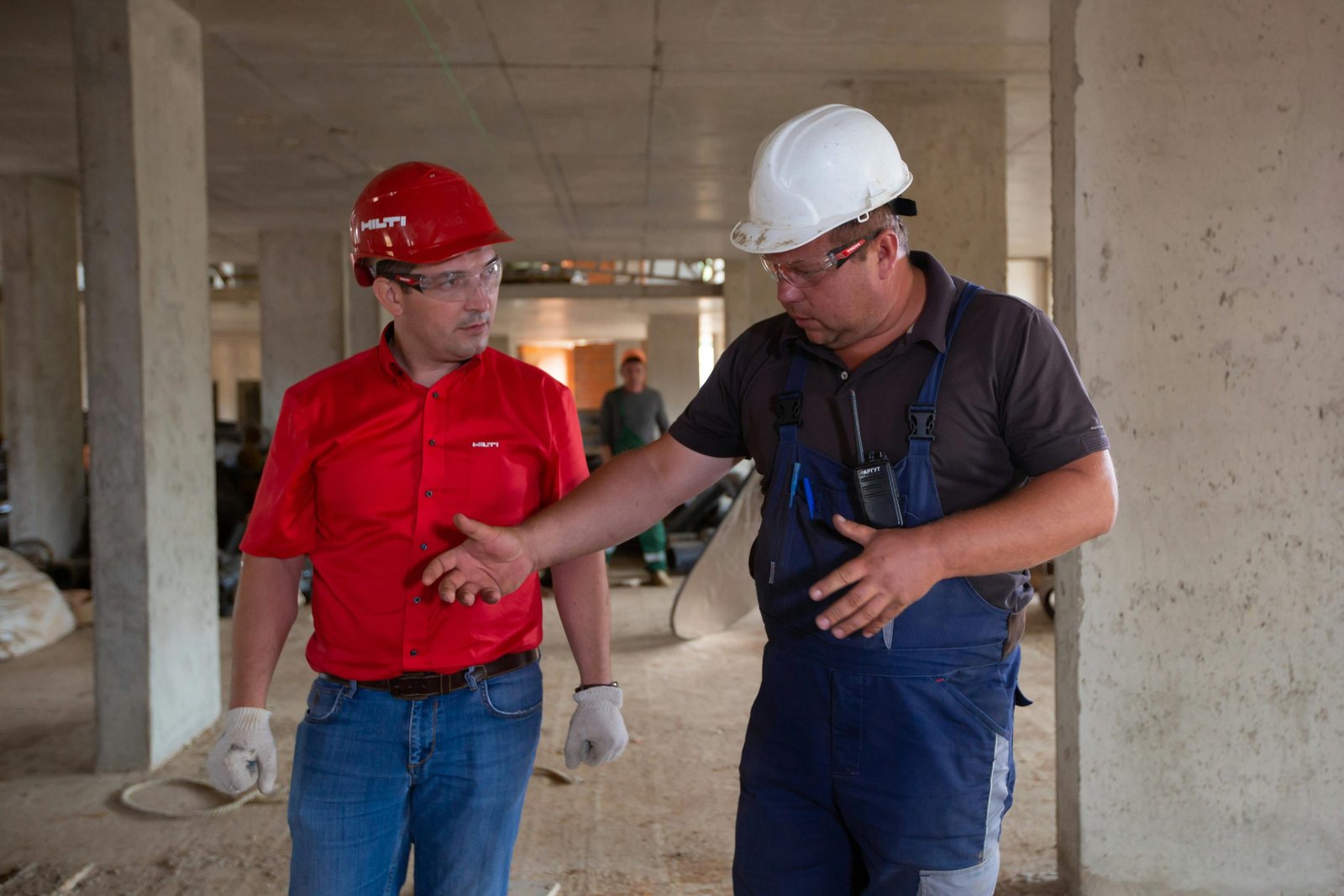 Construction workers discussing project details inside a commercial build site